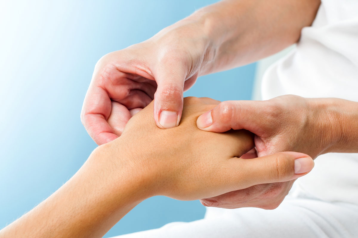 dr assessing hand for rheumatoid arthritis